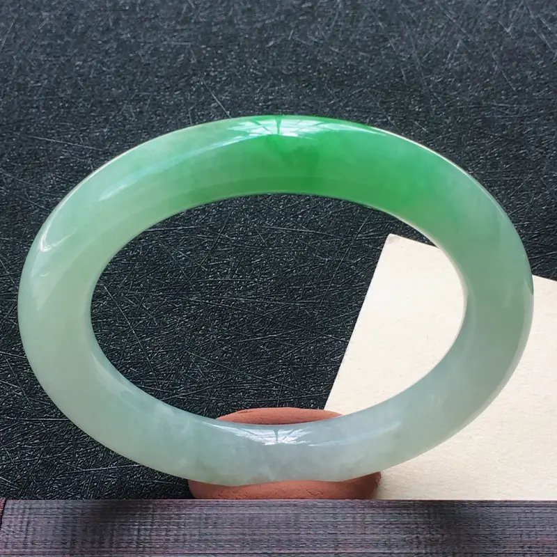 圈口：55.0mm 翡翠飘绿圆条手镯，种水好玉质细腻，种老水润，颜色漂亮。
