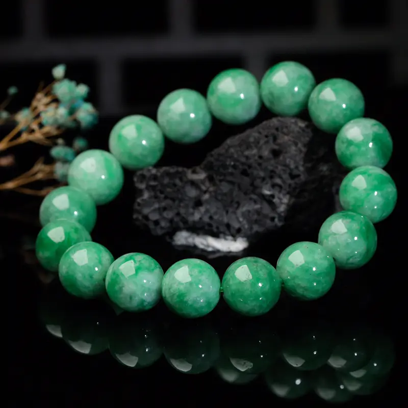 辣绿圆珠翡翠手串，共16颗珠子，取其中一颗珠尺寸大约13.1mm，清秀高雅，饱满圆润，上手佩戴优雅大方。有天然白棉。