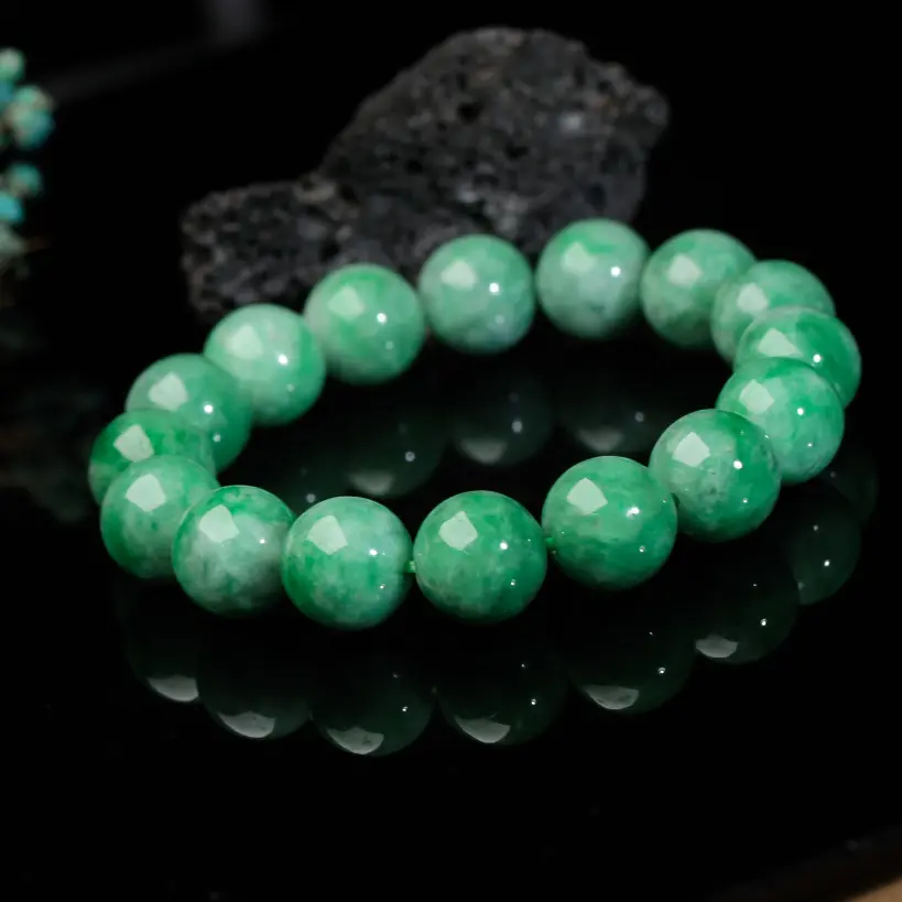 辣绿圆珠翡翠手串，共16颗珠子，取其中一颗珠尺寸大约13.1mm，清秀高雅，饱满圆润，上手佩戴优雅大方。有天然白棉。